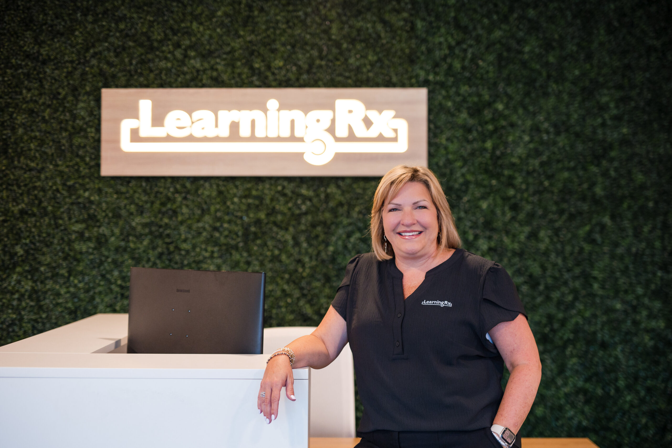 A franchisee stands at the front desk of her LearningRx center.